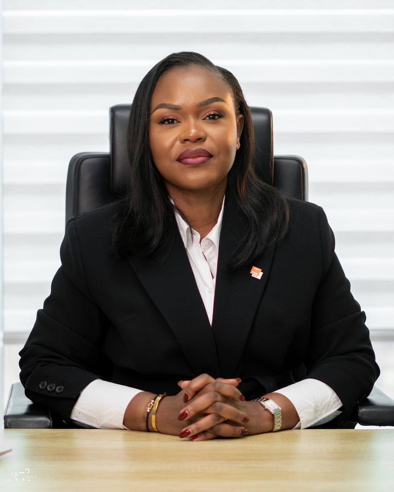 Audrey Koffi Niamkey assise, les mains jointes, en tenue noire.