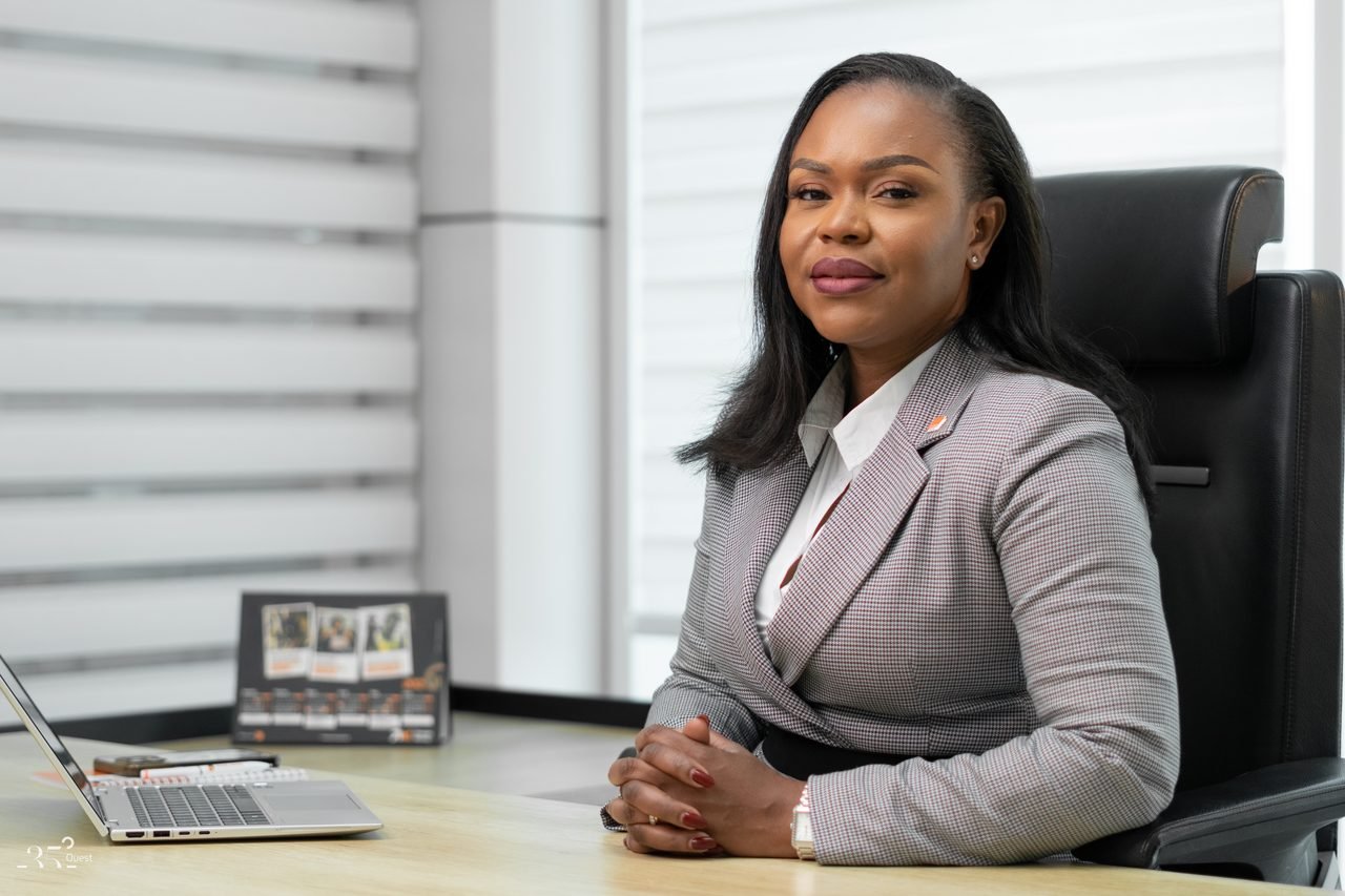 Audrey Koffi Niamkey assise à un bureau, en tenue grise.