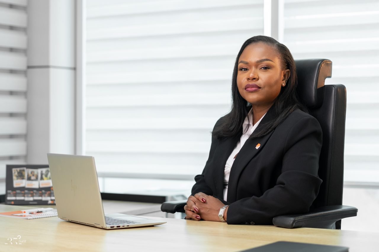 Audrey Koffi Niamkey assise à un bureau devant un ordinateur portable, en tenue noire.