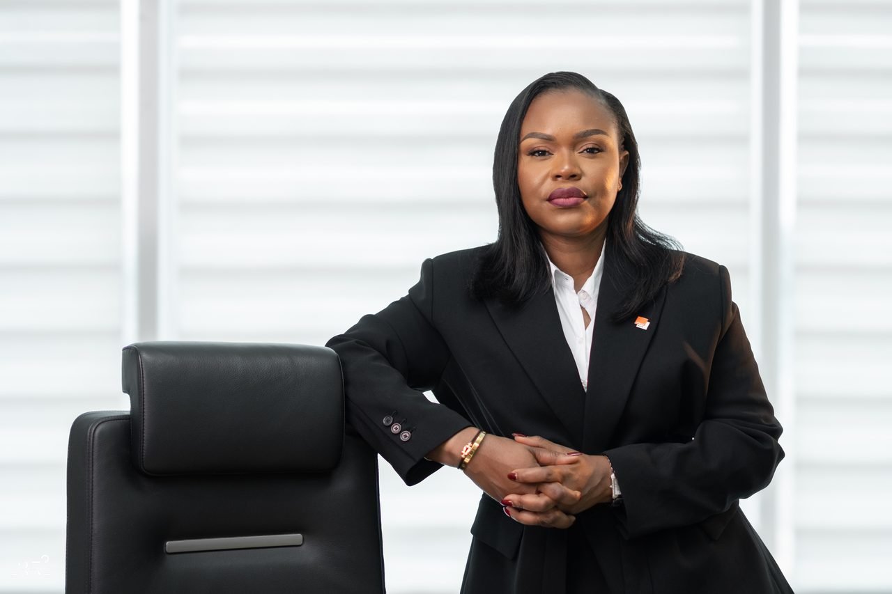 Audrey Koffi Niamkey appuyée sur un fauteuil, en tenue noire.